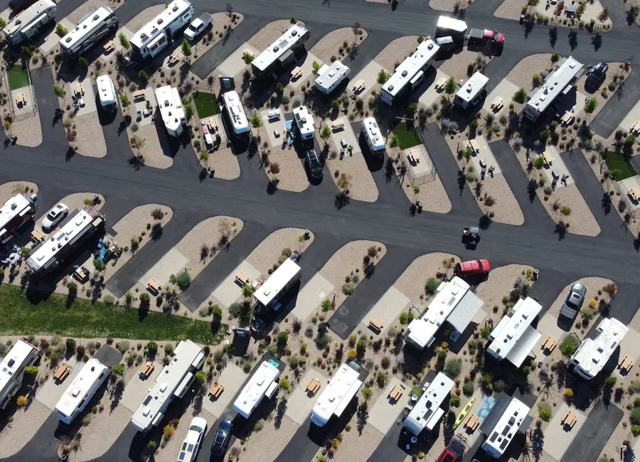 An aerial view of a neatly laid-out desert RV resort with angled pads.